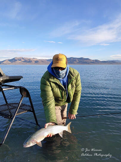 Fly fisherman at Pyramid Lake showing a Summit strain Lahontan cutthorat trout.
